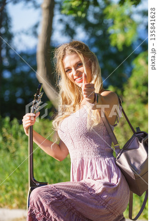 Woman playing acoustic guitar in park Woman playing acoustic guitar in park 135841628