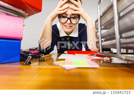 Depressed businesswoman sitting at desk Depressed businesswoman sitting at desk 135841723