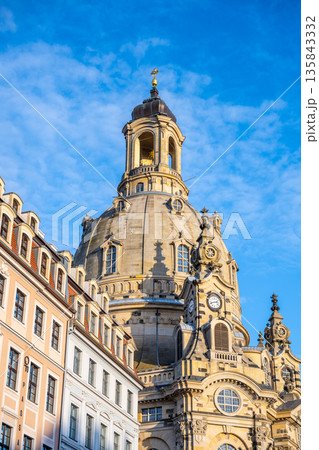 Frauenkirche stands tall in Dresden, Germany, showcasing its dome under a clear sky. Surrounding buildings add to the charm of this historic church during the Christmas festivities. Frauenkirche stands tall in Dresden, Germany, showcasing its dome under a clear sky. Surrounding buildings add to the charm of this historic church during the Christmas festivities. 135843332