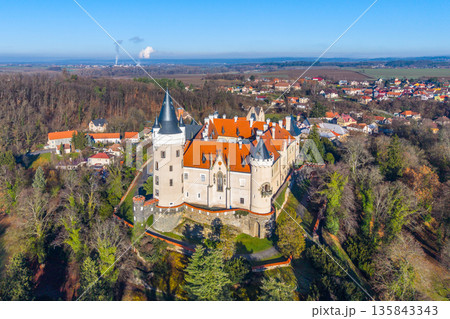 Aerial view of Zleby Castle showing its towers and rooftops. Surrounding area includes fields and small towns. The castle stands out in the landscape during clear weather. 135843343