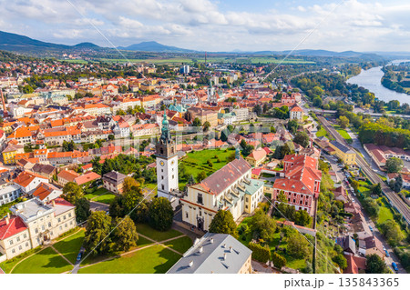Aerial view of St. Stephen's Cathedral in Litomerice shows its impressive architecture and surrounding scenery. The drone captures the vibrant colors of the city and the lush greenery nearby. Aerial view of St. Stephen's Cathedral in Litomerice shows its impressive architecture and surrounding scenery. The drone captures the vibrant colors of the city and the lush greenery nearby. 135843365