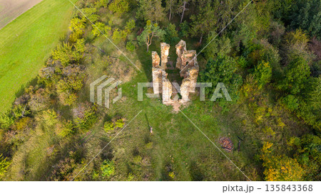 The drone view showcases the remnants of the Chapel of the Exaltation of the Holy Cross surrounded by lush greenery in Bristev. Nature reclaims history in the tranquil landscape. 135843368