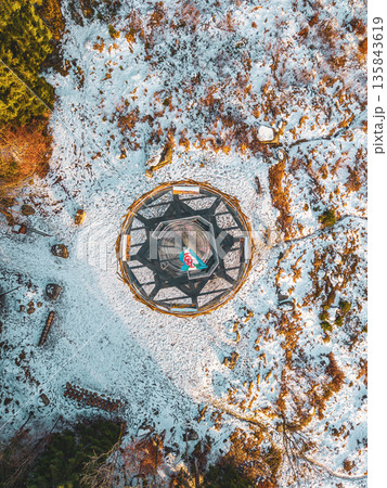 Svetly vrch lookout tower stands in Albrechtice surrounded by snow-covered terrain. Visitors can enjoy views of the Jizera mountains from this location during winter months. 135843619