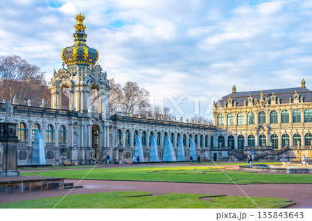 Visitors stroll through the Zwinger complex in Dresden, Germany. The palatial architecture and gardens create a festive atmosphere during the Christmas season. Visitors stroll through the Zwinger complex in Dresden, Germany. The palatial architecture and gardens create a festive atmosphere during the Christmas season. 135843643