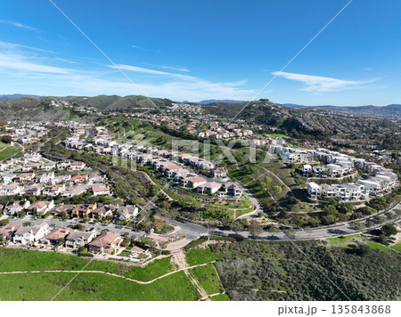 Aerial view over San Juan Capistrano, California, featuring the historic mission, library, sports courts, and an Amtrak train pulling into the downtown station. Aerial view over San Juan Capistrano, California, featuring the historic mission, library, sports courts, and an Amtrak train pulling into the downtown station. 135843868