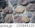 Natural stone wall texture with rough granite masonry pattern 135844120
