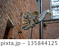 Decorative metal griffin sign on brick wall 135844125