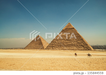 Desert Path Leading Toward the Iconic Egyptian Pyramids Desert Path Leading Toward the Iconic Egyptian Pyramids 135844559