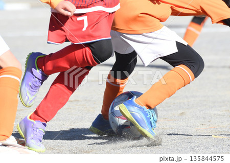 ドリブルするサッカー選手 135844575