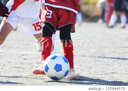 ドリブルするサッカー選手 135844579