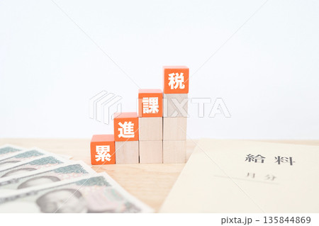 累進課税を示す給料袋と階段状ブロック。 累進課税を示す給料袋と階段状ブロック。 135844869
