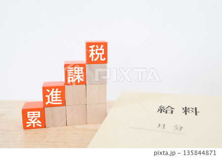 累進課税を示す給料袋と階段状ブロック。 累進課税を示す給料袋と階段状ブロック。 135844871