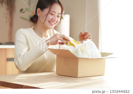 荷物を開封して嬉しそうな日本人女性 135844882
