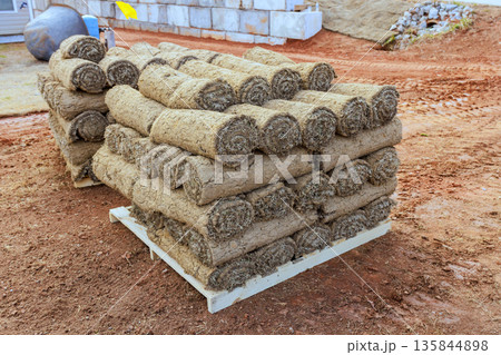Rolled sod is stacked neatly on pallet, waiting to be installed on lawn at construction site Rolled sod is stacked neatly on pallet, waiting to be installed on lawn at construction site 135844898