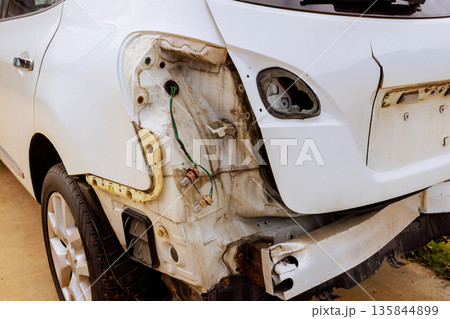 White car is parked with visible damage at back area shows exposed wiring missing piece ready for renovation White car is parked with visible damage at back area shows exposed wiring missing piece ready for renovation 135844899