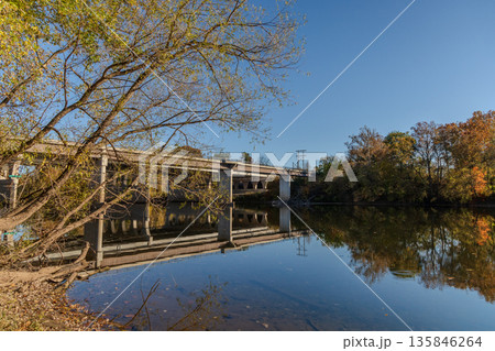 A bridge spans a river with a reflection of the bridge in the water A bridge spans a river with a reflection of the bridge in the water 135846264