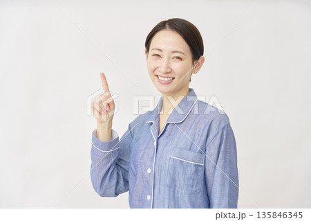 パジャマを着た女性 左を指差す 白バック パジャマを着た女性 左を指差す 白バック 135846345