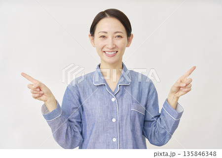 パジャマを着た女性 左右を指差す 白バック パジャマを着た女性 左右を指差す 白バック 135846348