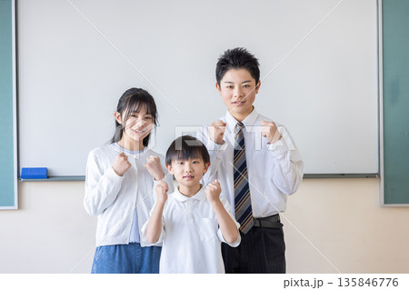 ホワイトボードの前でガッツポーズする3人の子ども	 135846776