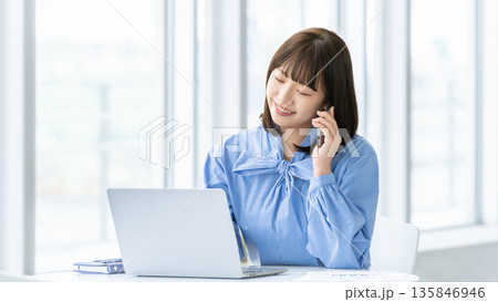 スマートフォンで話す女性・ビジネスウーマン スマートフォンで話す女性・ビジネスウーマン 135846946