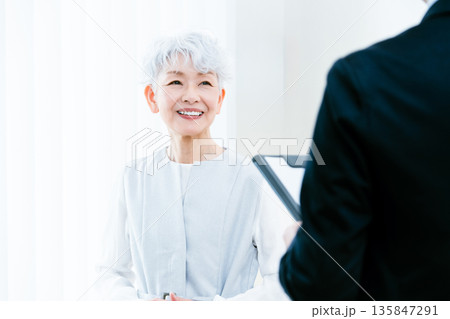 説明を受けるシニア女性 説明を受けるシニア女性 135847291