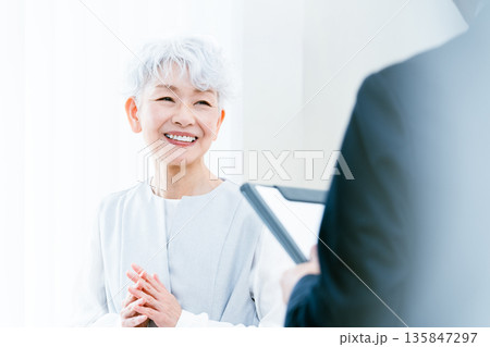 説明を受けるシニア女性 説明を受けるシニア女性 135847297