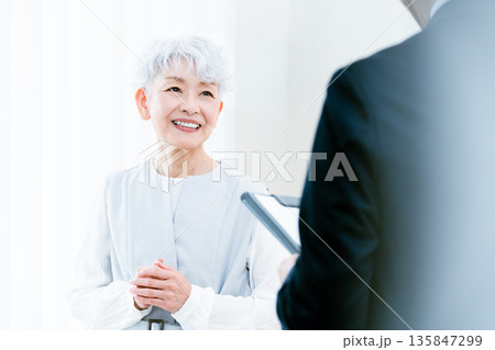 説明を受けるシニア女性 説明を受けるシニア女性 135847299