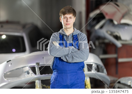 Service station young man employee works in repair box, department Service station young man employee works in repair box, department 135847475