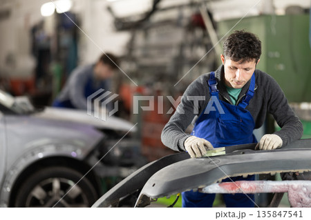 Man auto mechanic handle polishes body parts 135847541