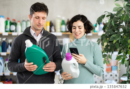 Married couple scanning detergent on mobile Married couple scanning detergent on mobile 135847632