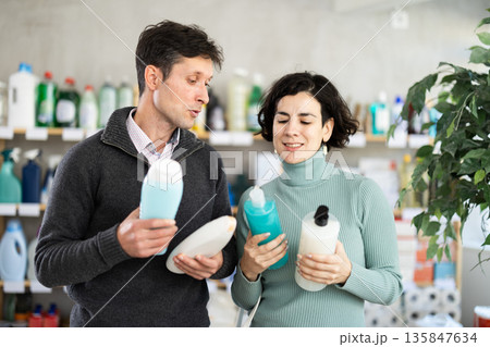 married couple chooses shower gel and shampoos 135847634