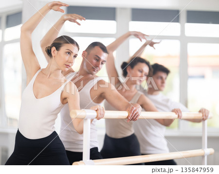 Group of dancers doing plie at barre Group of dancers doing plie at barre 135847959
