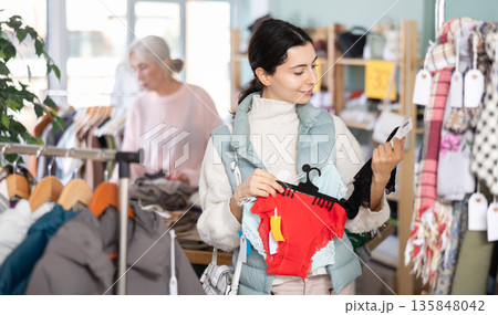 Female shopper selects panties in fashionable clothing boutique 135848042