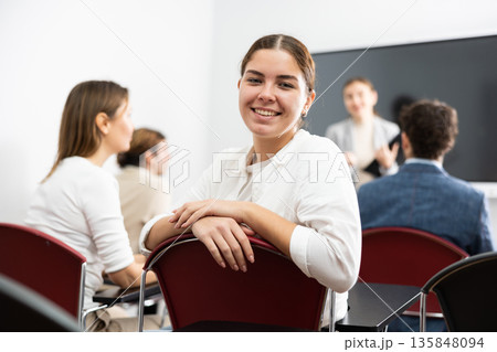 Young smiling female student sitting in college class 135848094