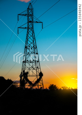 Power tower backlit by a sunset. Electric transmission tower backlit by the sunset 135848442