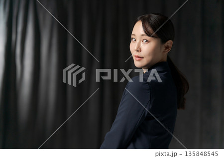 20代のスーツの女性(黒背景) 20代のスーツの女性(黒背景) 135848545