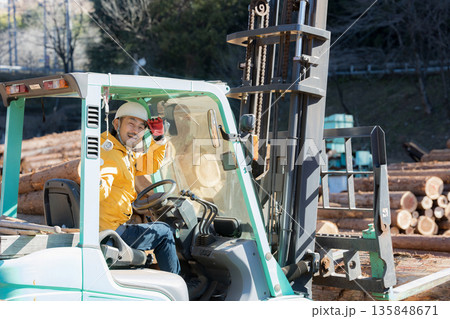 フォークリフトで木材を運ぶ作業員カメラ目線 135848671