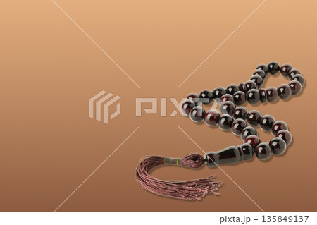 Prayer beads shine against a warm backdrop for Ramadan 135849137