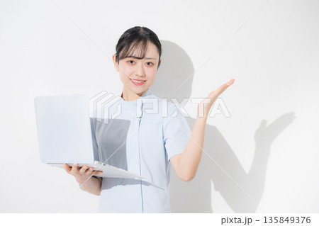 水色のナース服を着たパソコンを持つ看護師カメラ目線 転職や採用などのイメージ受付のオススメや案内 水色のナース服を着たパソコンを持つ看護師カメラ目線 転職や採用などのイメージ受付のオススメや案内 135849376