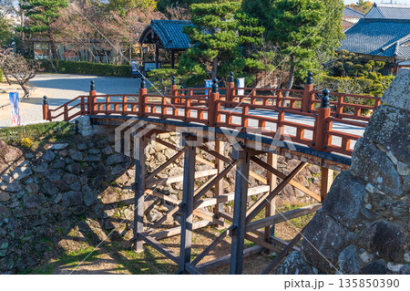 青空と大和郡山城の東隅櫓と開花を待ち望む桜の木 135850390