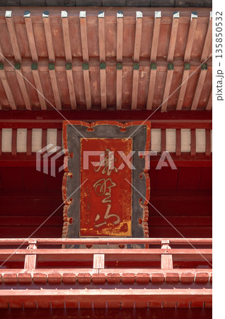 寺院の山門に掲げられた扁額と朱色の伝統建築のディテール 135850532