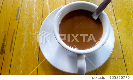 Close Up Creamy Coffee Latte in White Cup on Yellow Wood Background 135850770