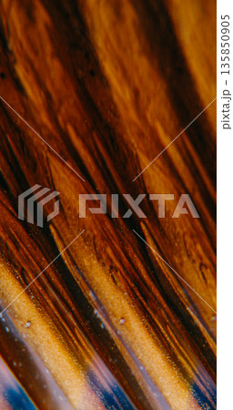 Shimmering stream blur. Dripping ink. Black pigment leak on yellow orange lava texture. Color prism optical effect abstract background. Shimmering stream blur. Dripping ink. Black pigment leak on yellow orange lava texture. Color prism optical effect abstract background. 135850905