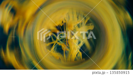 Smoke defocused vortex. Art fume. Yellow bright paint drop curl spilling in fluid. Round lens abstract tunnel color on black background. 135850915