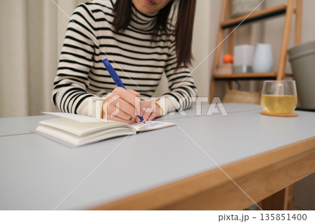 日記を書く女性の手元のアップ 135851400
