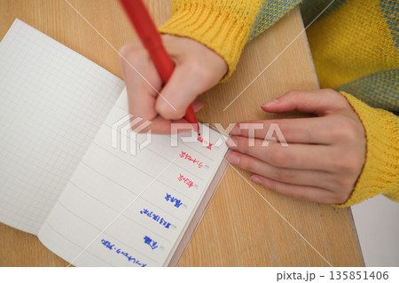 予定を書きこむ女性の手元の俯瞰クローズアップ 135851406