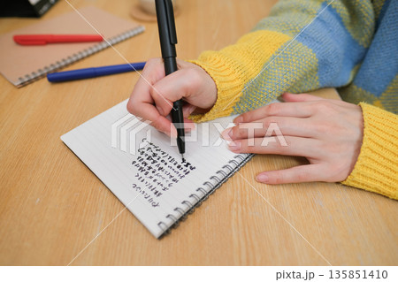 ジャーナリングをする女性の手元のクローズアップ 135851410