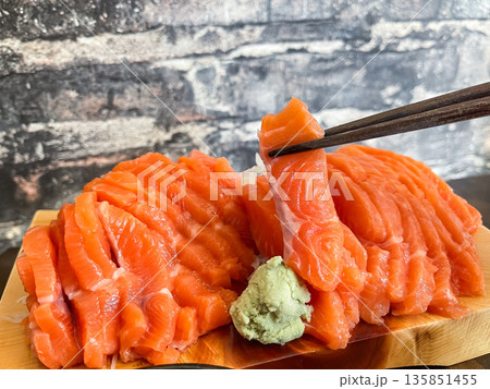 新鮮なサーモンの刺身のとわさび。箸持ちした刺身の断面。 135851455