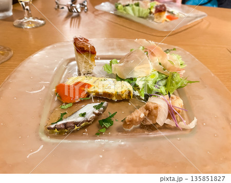 前菜プレート。タコマリネ、プロシュートサラダ、卵料理などが乗ったアンティパスト。 前菜プレート。タコマリネ、プロシュートサラダ、卵料理などが乗ったアンティパスト。 135851827