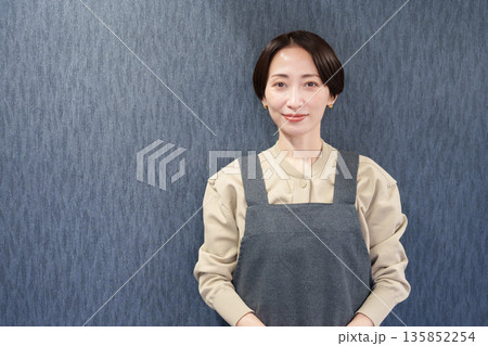 エプロンを着た笑顔の女性店員 エプロンを着た笑顔の女性店員 135852254